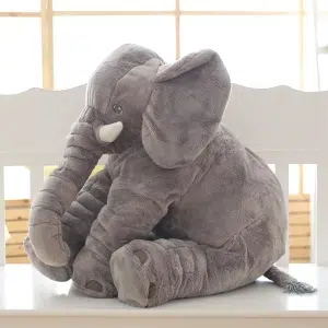 Przytulanka przedstawiająca siedzącego szarego słonia. Ma duże uszy i kły. Bawełniany plusz jest miękki.