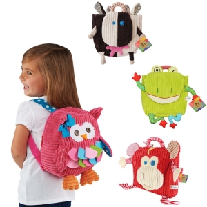 Dziewczynka z pluszowym plecakiem w kształcie różowej sowy i trzema innymi pluszowymi plecakami przedstawiającymi krowę, żabę i czerwoną małpkę